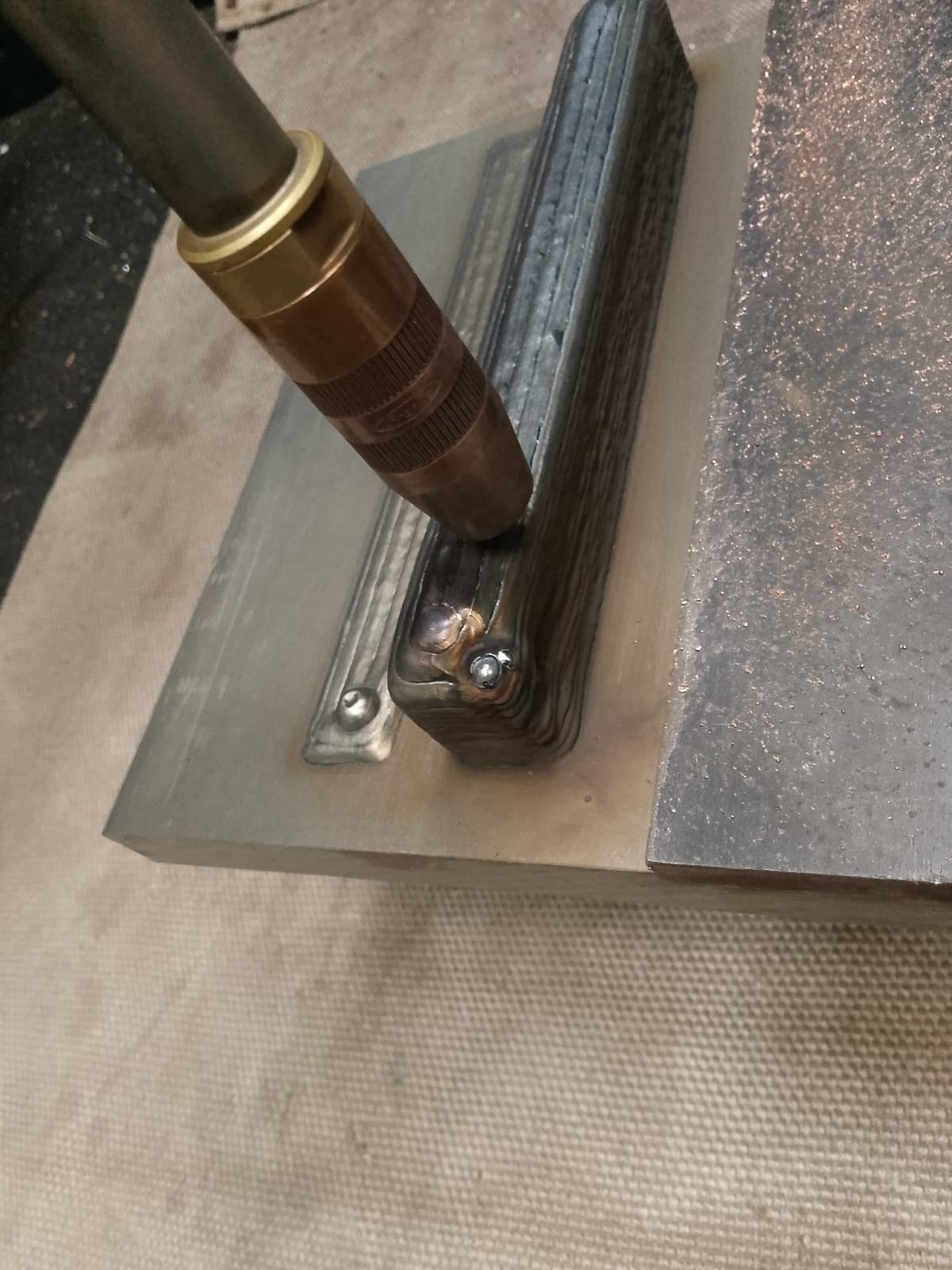 Close-up of MIG torch over deposited DOOSAN WAAM layers